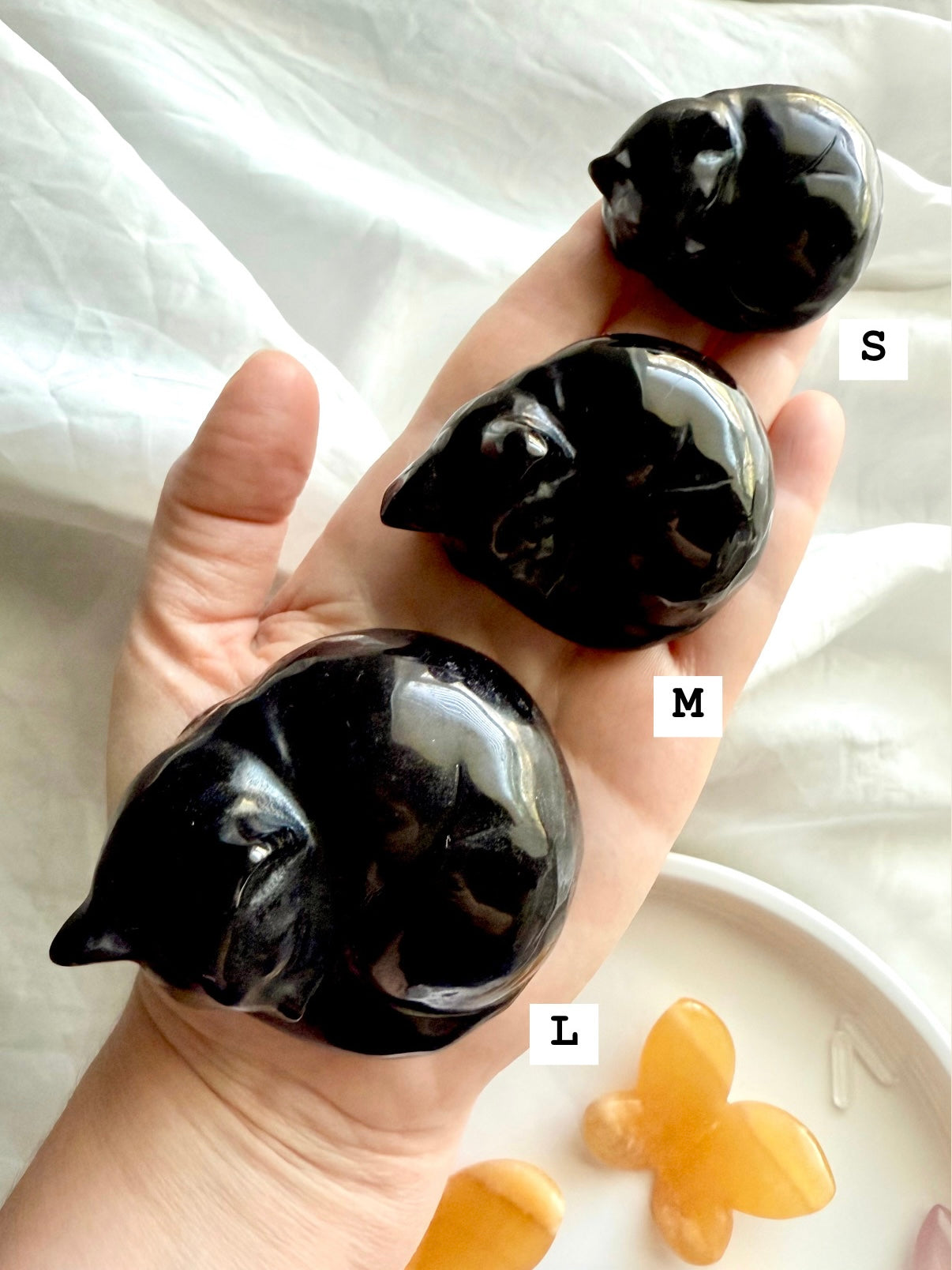 Three Obsidian Crystal Cat carvings shown in hand with sizes marked — sweet spiritual décor & pet memorial crystals.