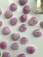 Angled view of Pink Kunzite crystal hearts on white — soothing heart chakra stones for emotional support & spiritual healing.