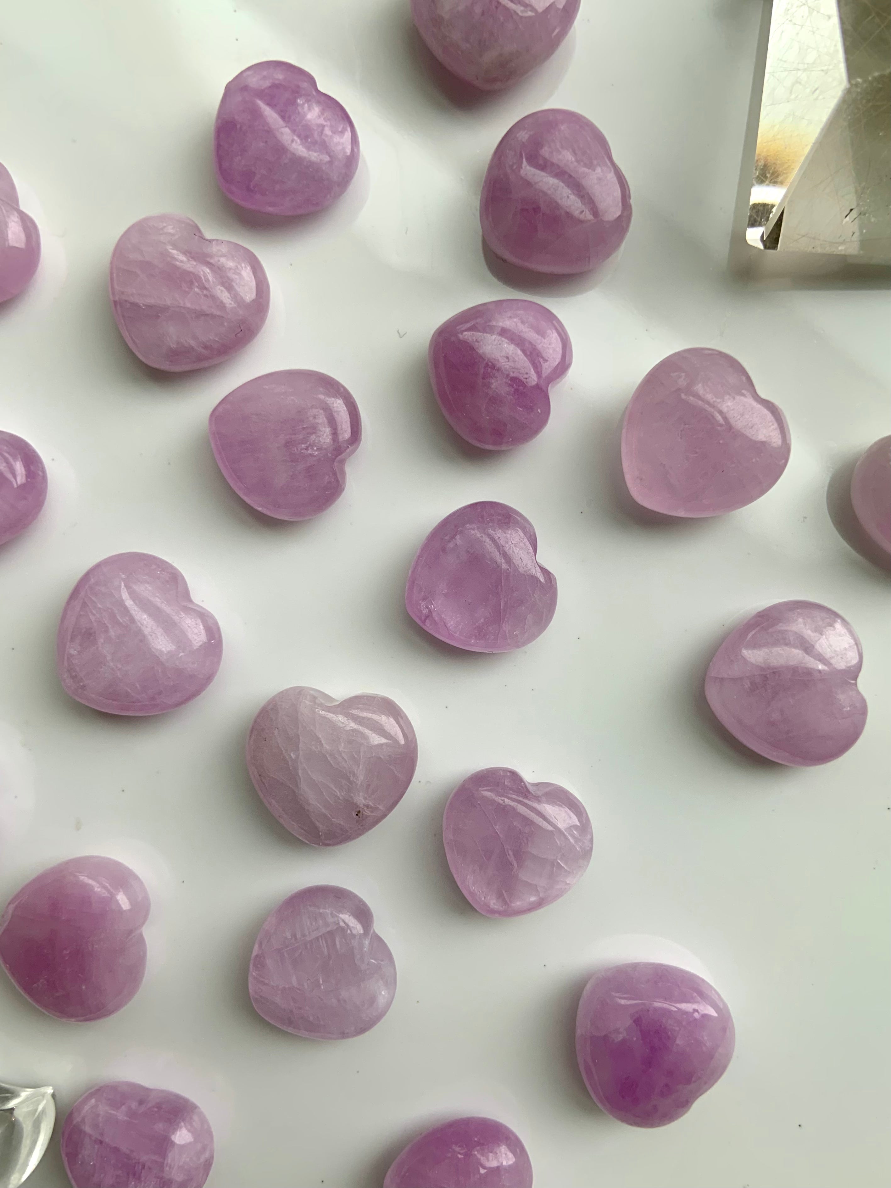 Angled view of Pink Kunzite crystal hearts on white — soothing heart chakra stones for emotional support & spiritual healing.