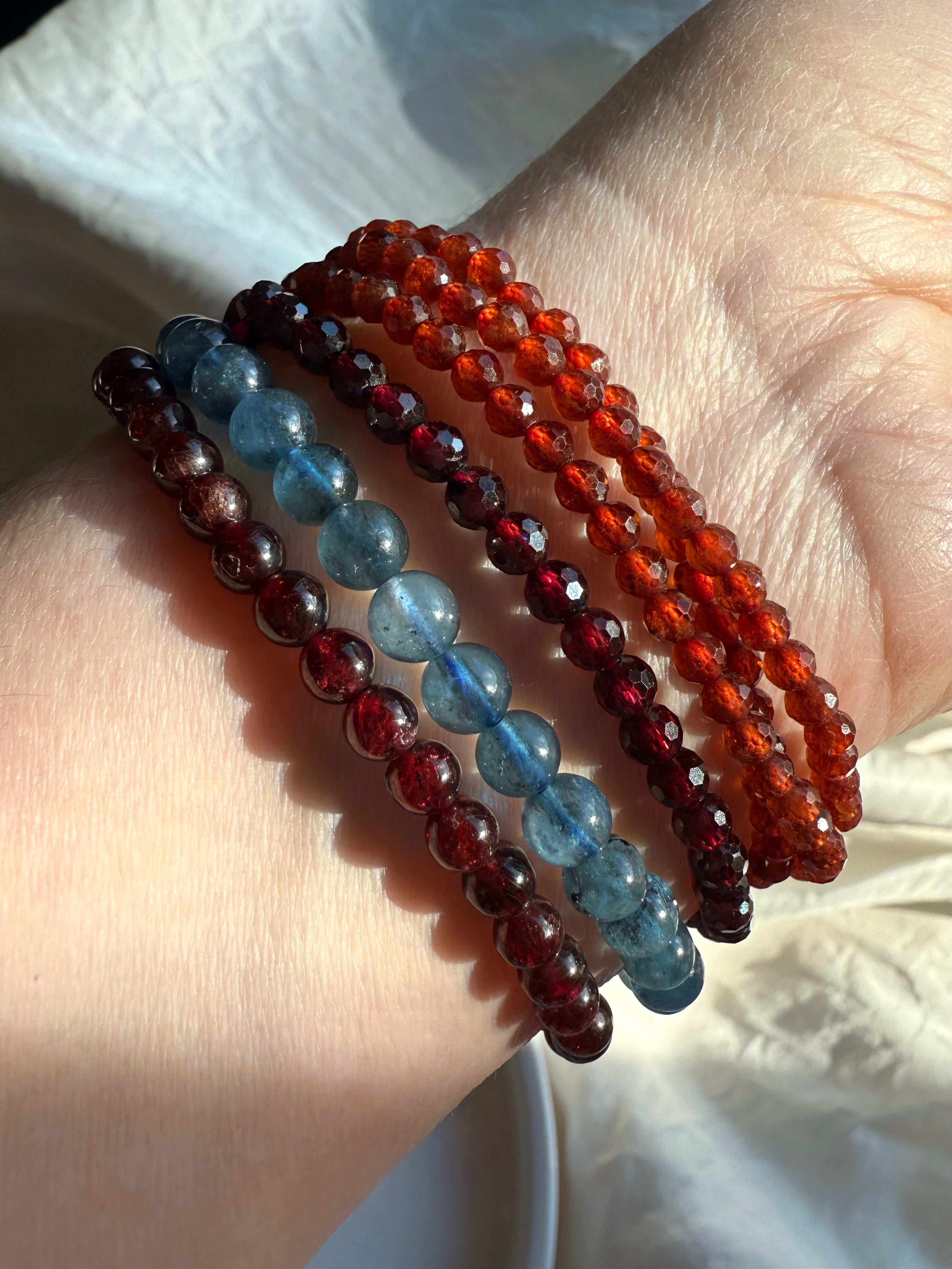 Our Faceted Spessartite Garnet Wrap Bracelet shown with Almandine Garnet + Aquamarine bracelets