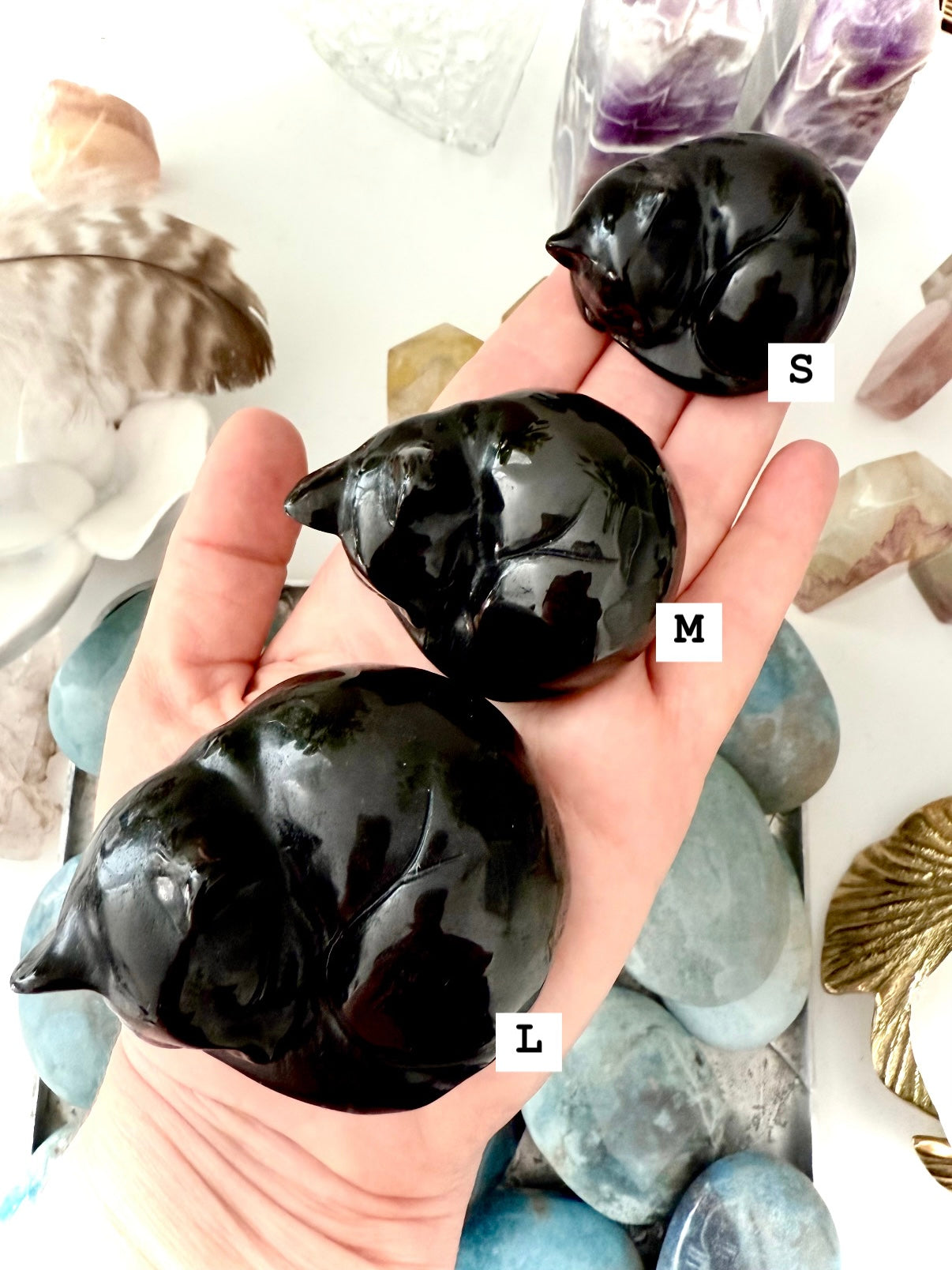 Three Black Obsidian cat carvings with size markers for scale — sleeping crystal cats for protection & remembrance.