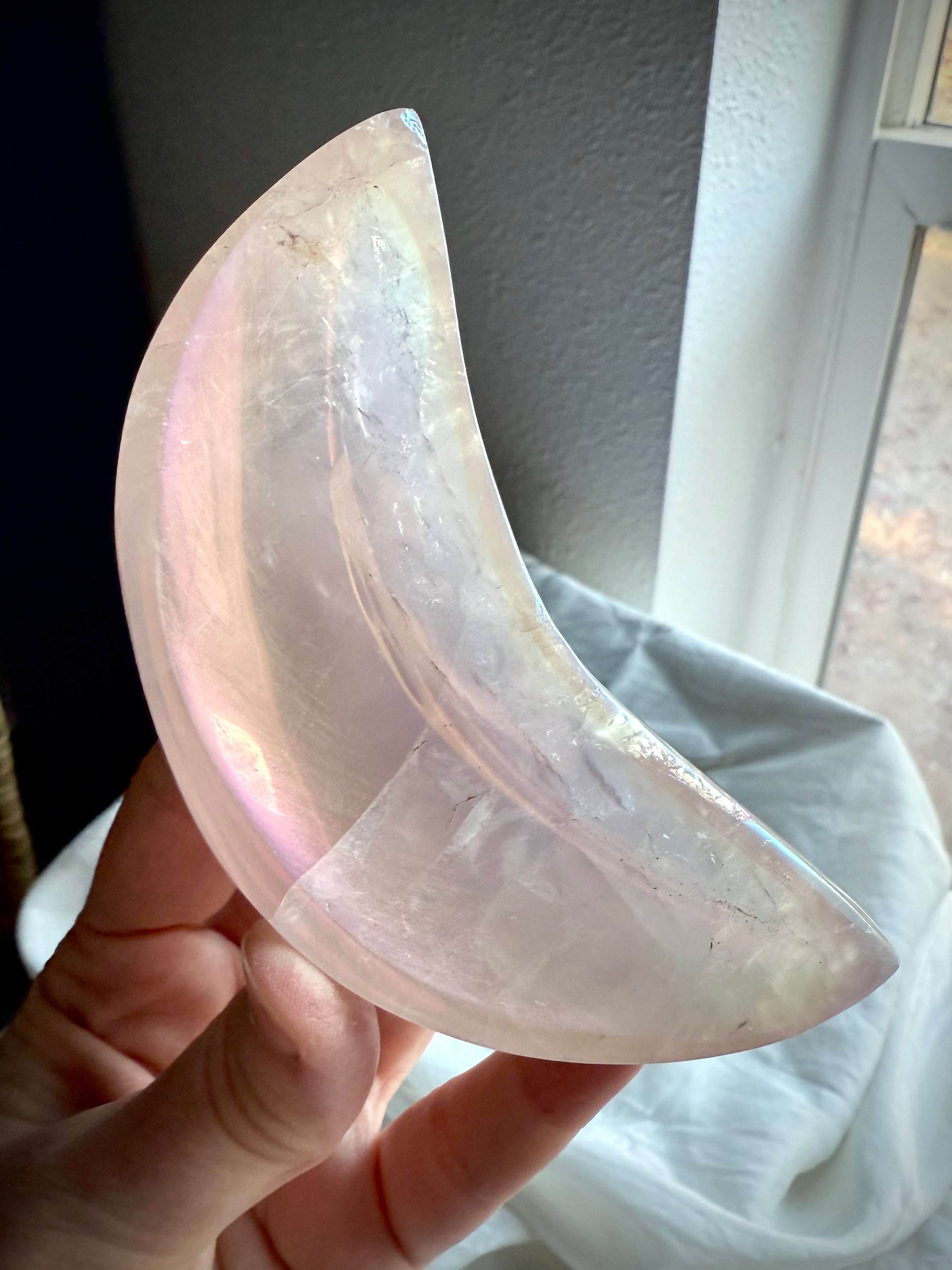 Dreamy pink Aura Rose Quartz crescent bowl held to the light for altar decor, healing rituals, or crystal display