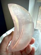 Dreamy pink Aura Rose Quartz crescent bowl held to the light showing the dreamy opalescent pink crystal