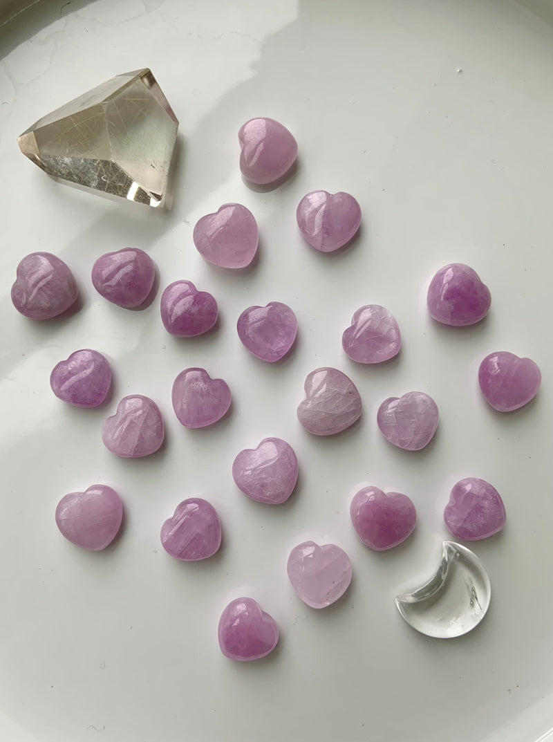 Mini Heart Shaped Kunzite Crystals shown on a white background with other crystals as accents