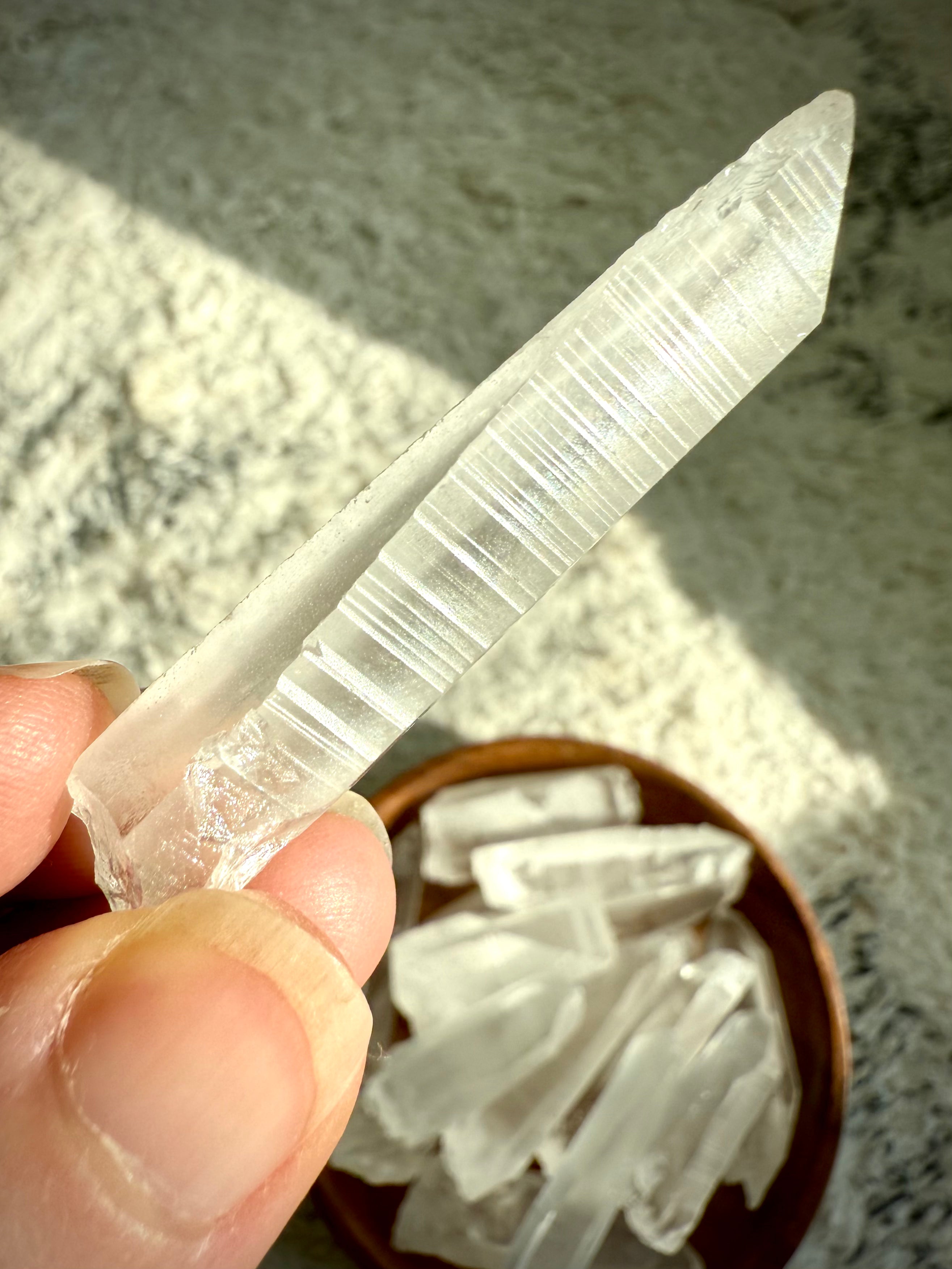Close-up of Lemurian Seed Quartz showing horizontal ladder-like striations — signature lines believed to hold ancient wisdom & encoded light.