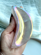 Shimmery Aura Rose Quartz bowl in crescent moon shape, held in hand