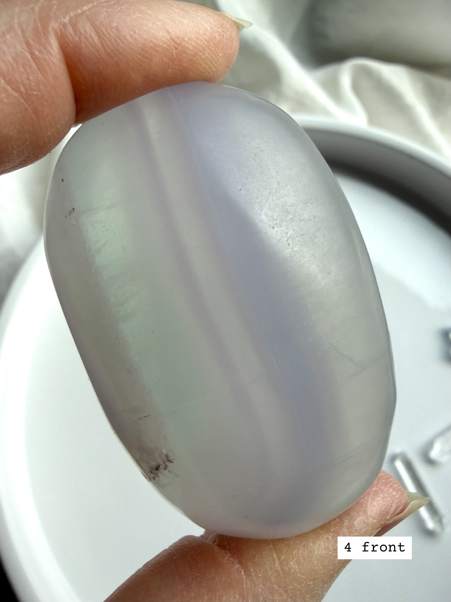 yttrium fluorite palm stone #4 front view with lavender color bands and smooth polished surface