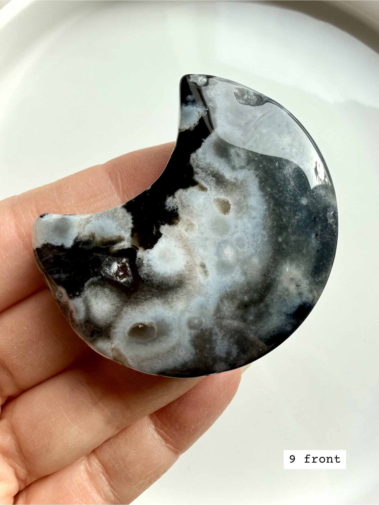 black flower agate moon carving #9 front showing crescent shape with bold white bloom formations
