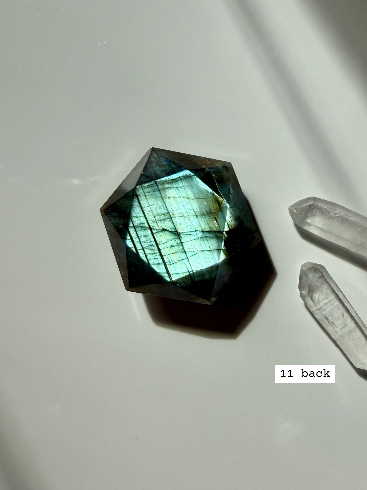 back view of polished faceted labradorite sacred geometry crystal with luminous blue flash number 11