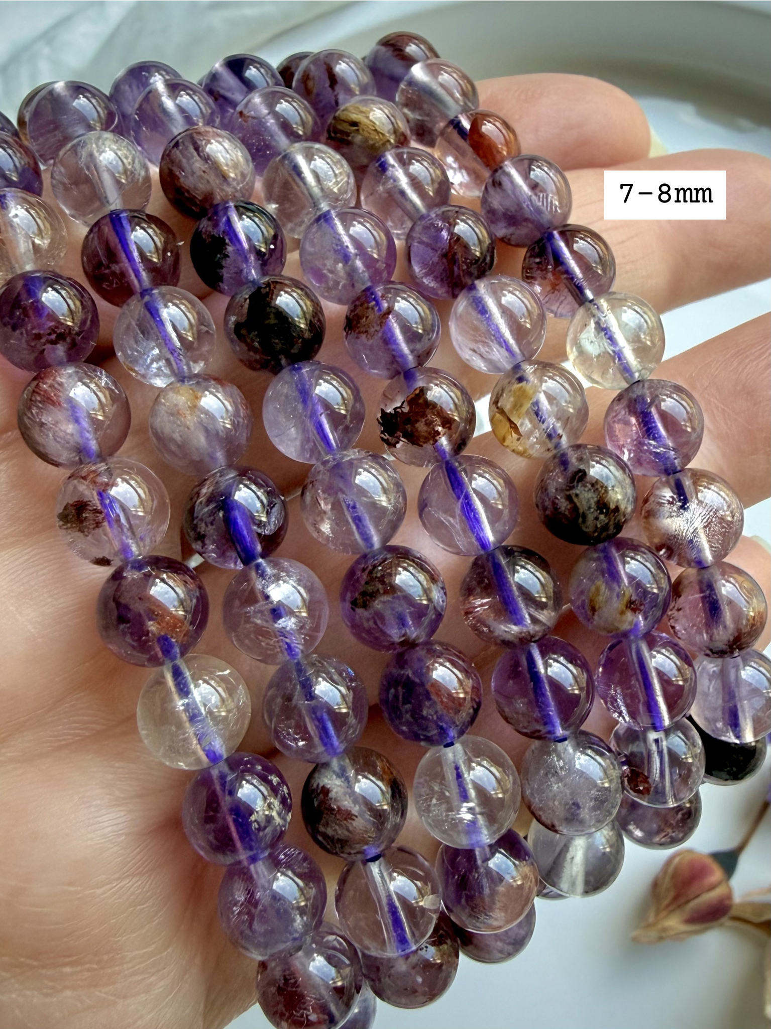 Close up of Super 7 Amethyst gemstone beads size 7-8mm showing natural mineral patterns and inclusions