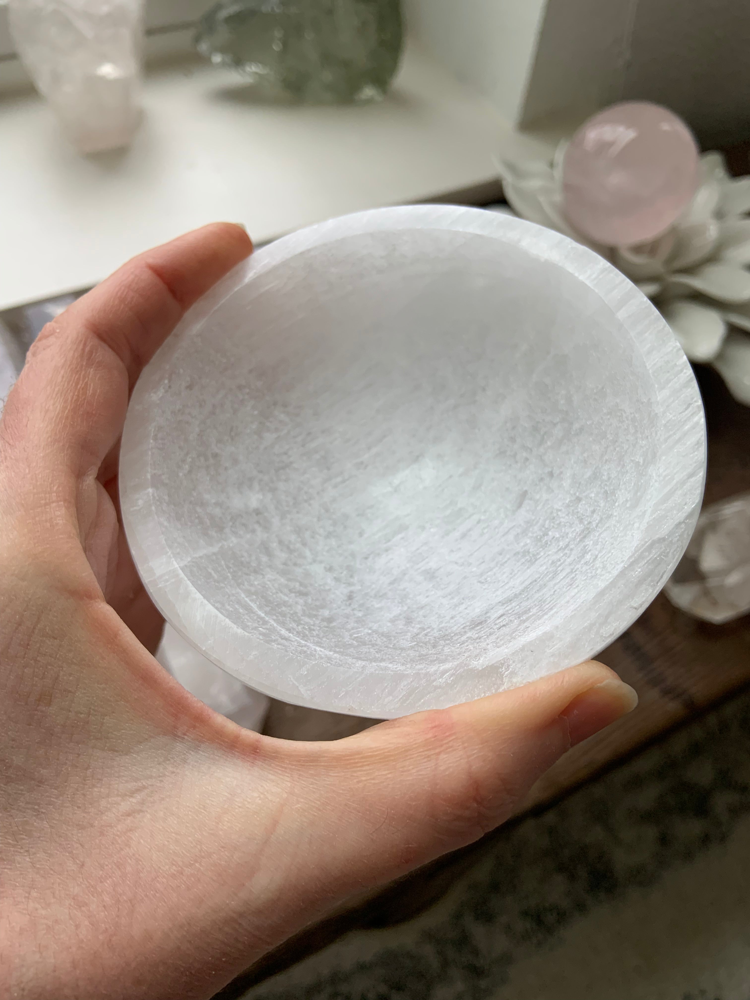 Hand holding round Selenite crystal bowl — polished round bowl for energy clearing and meditation