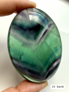 Teal fluorite palm stone #10 back view showing layered blue green banding and natural inclusions