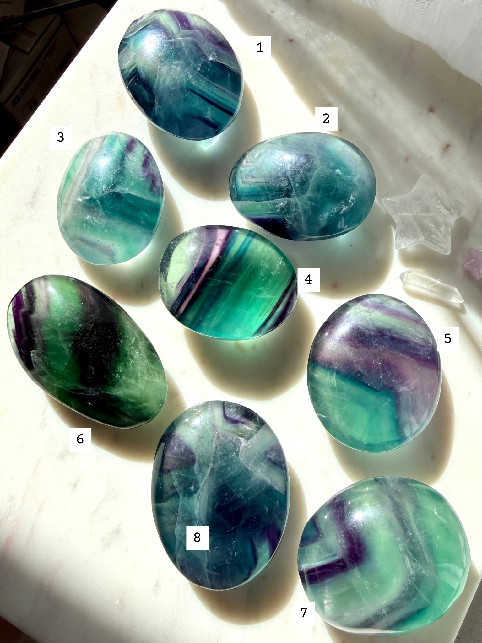 Rainbow Fluorite Palm Stones showing front and back with flowing color bands and translucent color windows