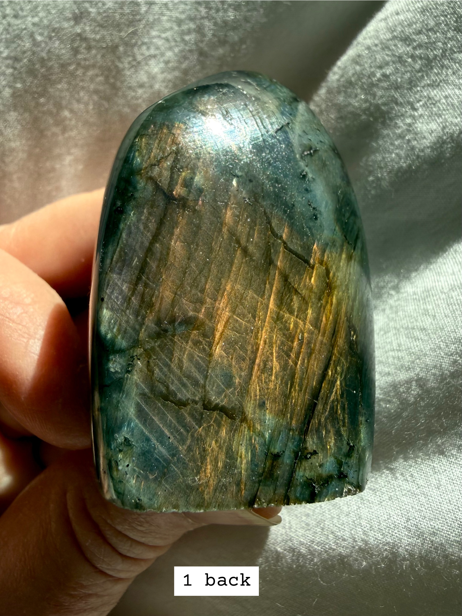 Back side of labradorite freeform showing peachy rainbow flash.