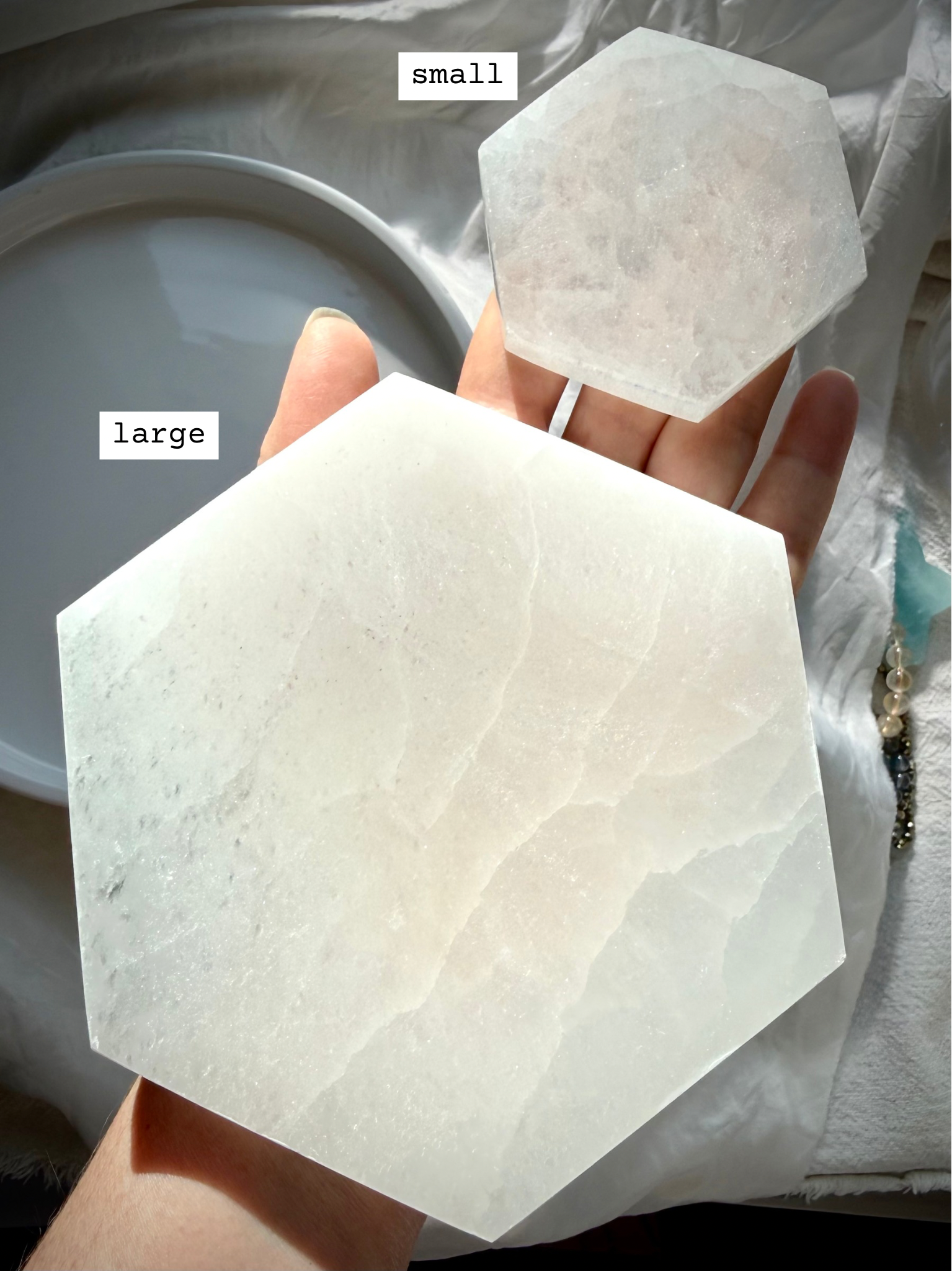 Two Hexagonal Selenite Plates shown on hand marked with sizes for scale.