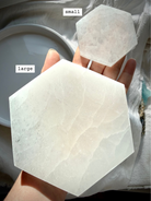 Two Hexagonal Selenite Plates shown on hand marked with sizes for scale.