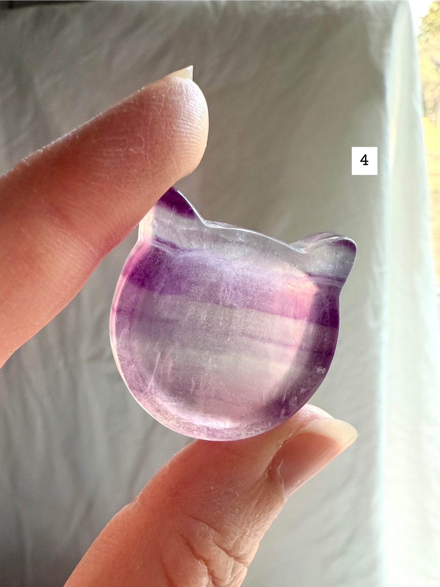 Fluorite cat-shaped crystal bowl held to the light – mini ring dish and jewelry holder