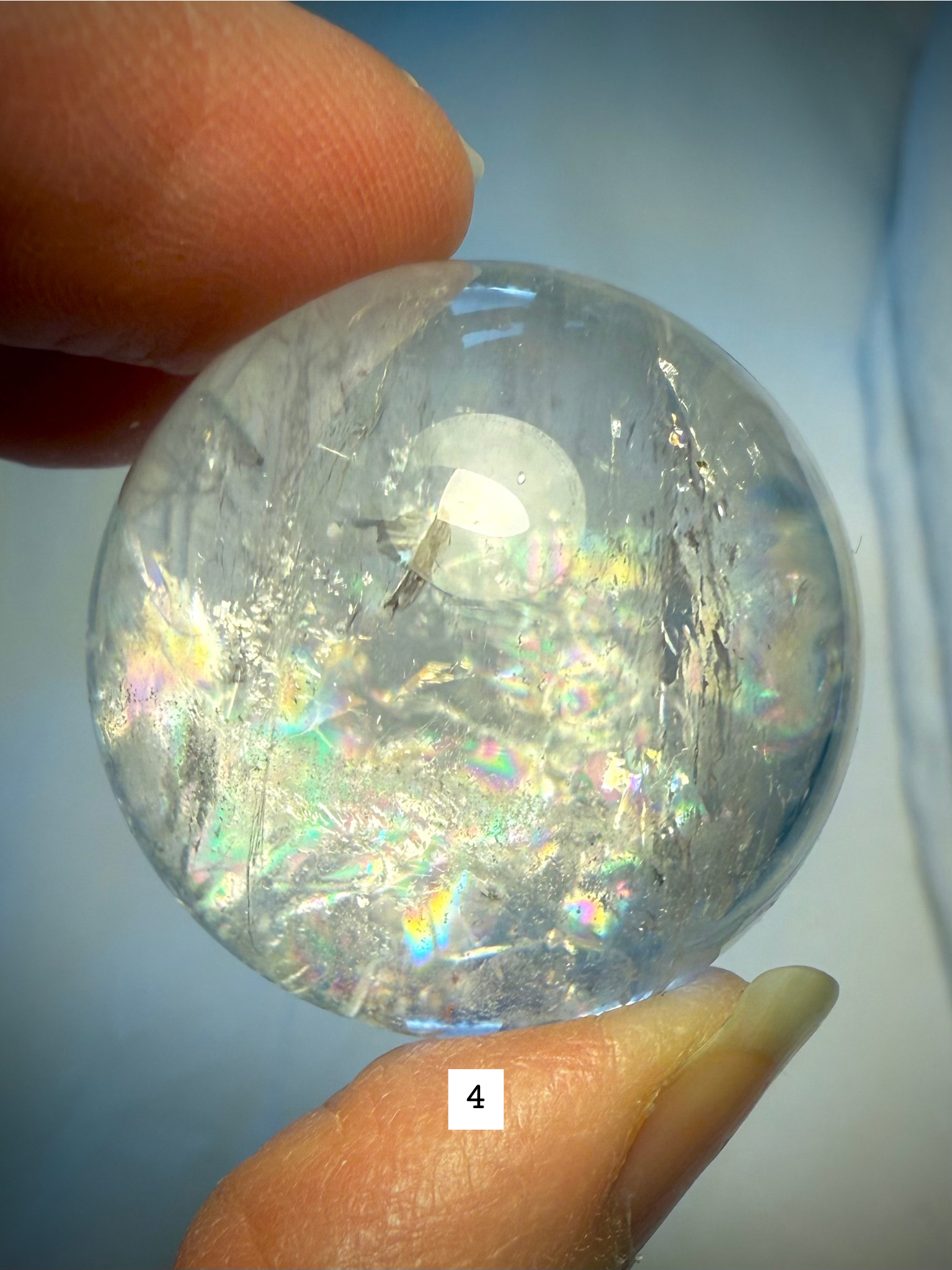 Rainbow Quartz sphere #4 featuring subtle rainbows, veils, and clear quartz transparency in bright light.