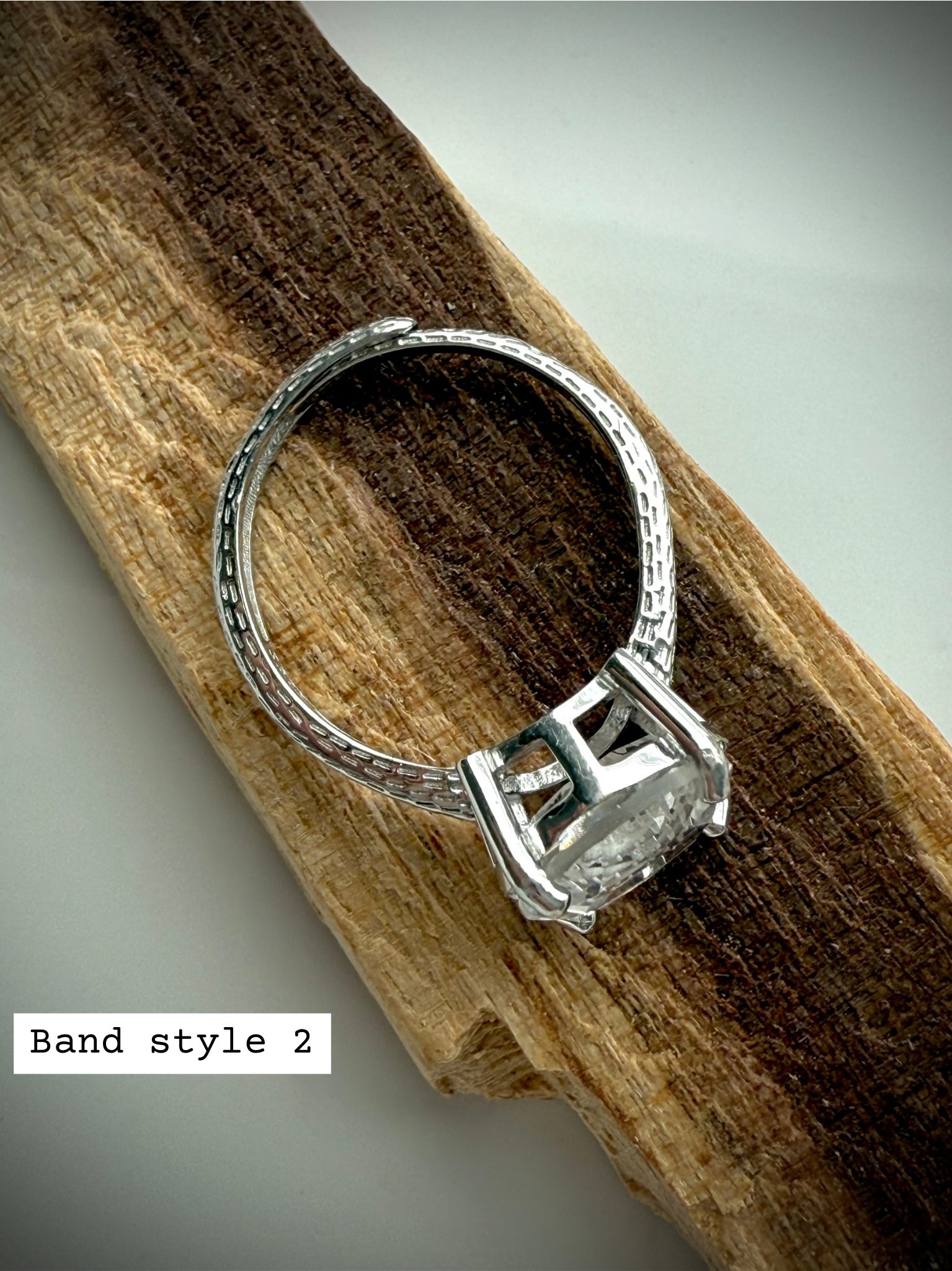 side view of option 2: sterling silver moon ring with adjustable band on wooden surface