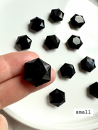 Mini Black Obsidian hexagon crystal balanced on fingertips for size reference, polished gemstone for grounding and energetic shielding