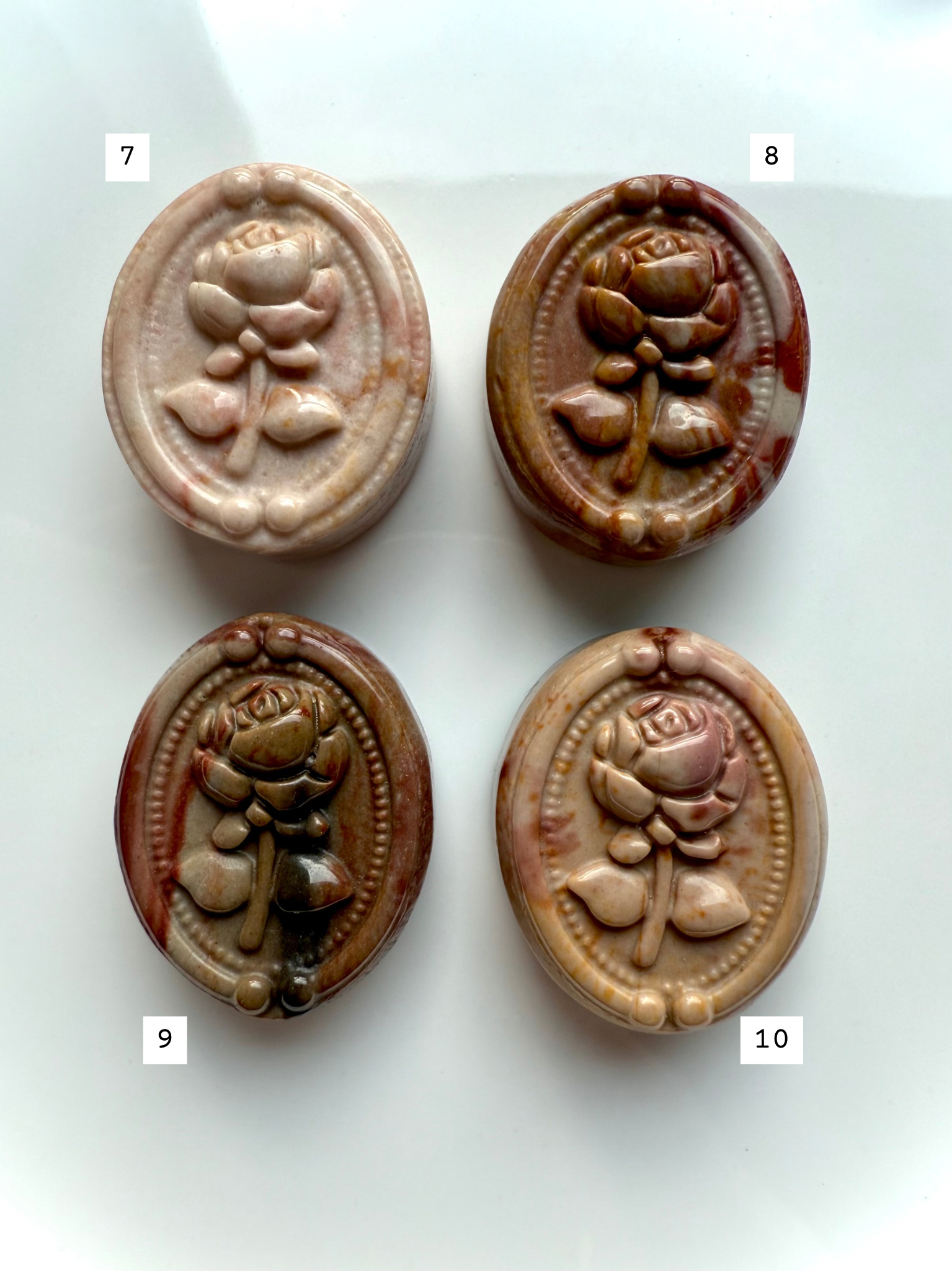 Polychrome Jasper rose carvings displayed in a four-piece arrangement — soothing earth-tone crystals for stability, comfort, and emotional grounding.