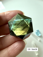 faceted labradorite hexagon with gold green flash held in hand healing crystal star of david carving for intuition