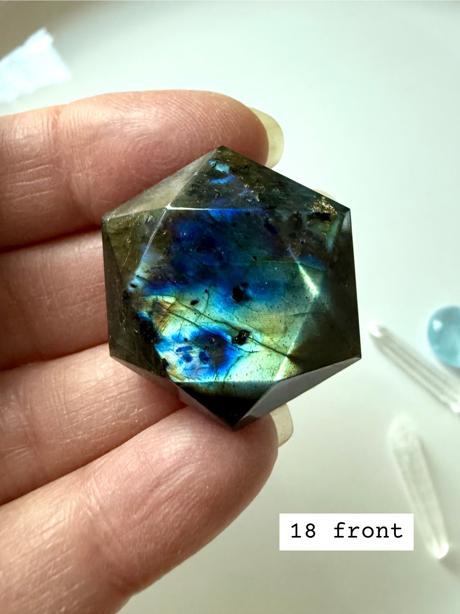 faceted labradorite hexagon with blue green flash held in hand crystal star of david for intuition and third eye chakra