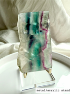 Statement fluorite slab crystal with luminous rainbow banding shown on elegant display stand