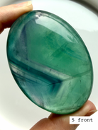 Teal fluorite palm stone #5 front view featuring bold blue green banding and polished oval shape
