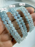 Aquamarine bracelets shown on hand in soft blue ombré – marked with bead sizes for comparison