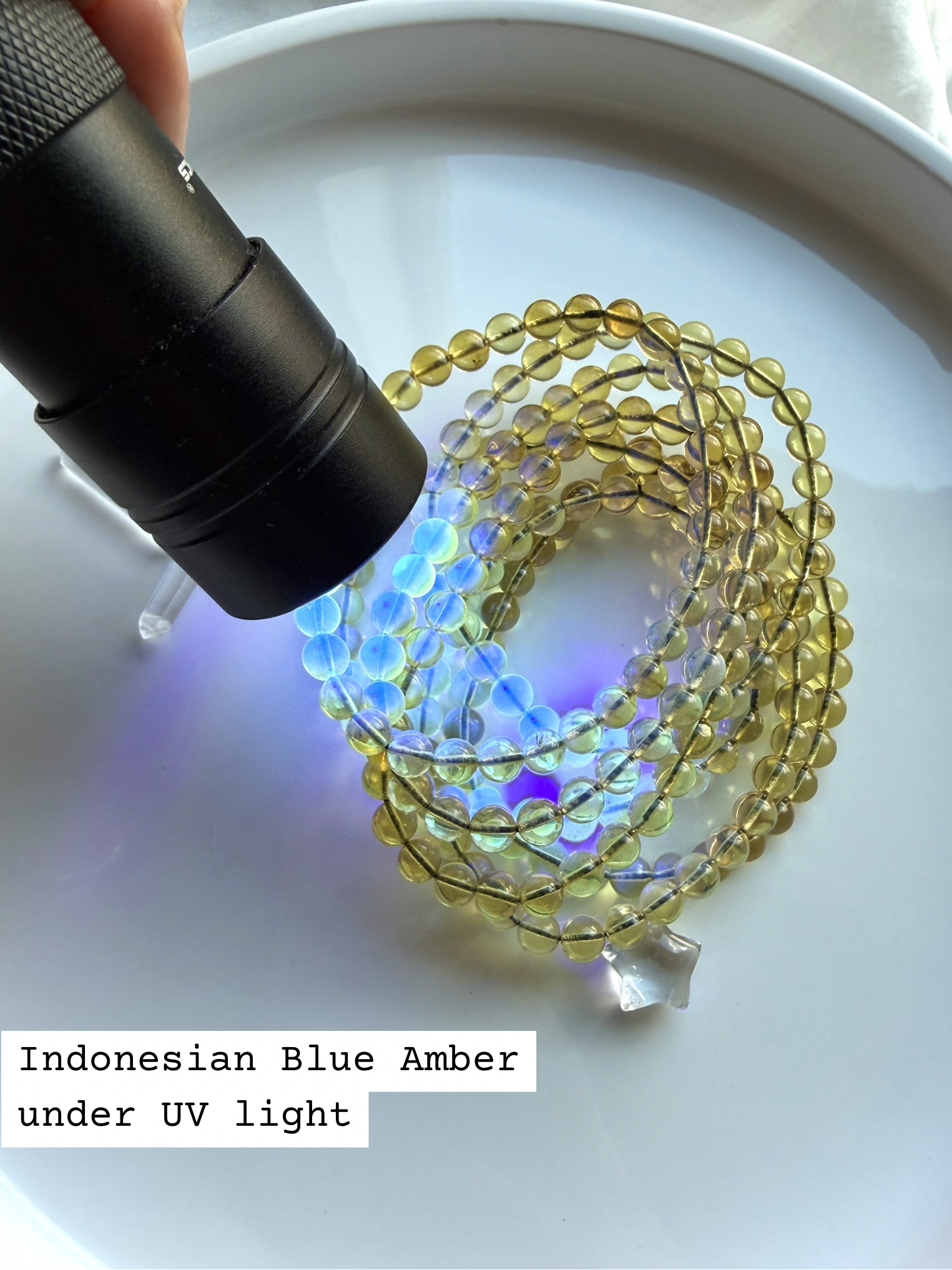 Indonesian blue amber bracelet glowing under UV light – UV reactive amber crystal bead bracelet