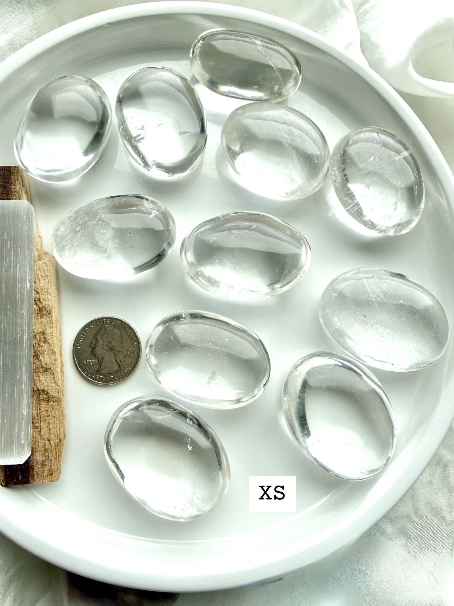Clear quartz meditation stones, marked XS shown with a US Quarter for scale, smooth polished palm stones for energy work