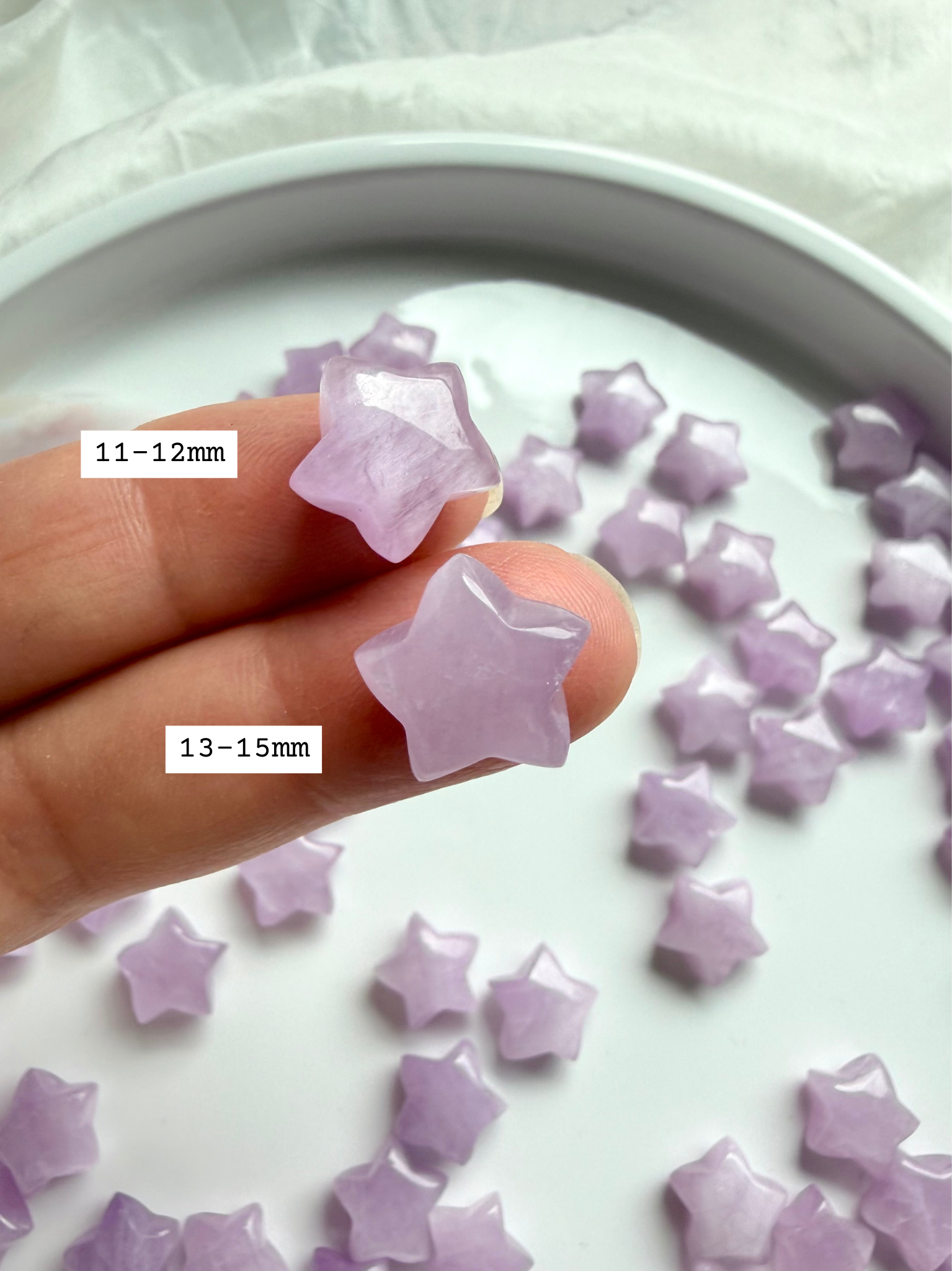 Closeup of two Kunzite stars marked with size — miniature crystal star carvings for heart chakra energy work.