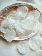 clear quartz worry stones arranged on shell dish for meditation clarity and healing energy