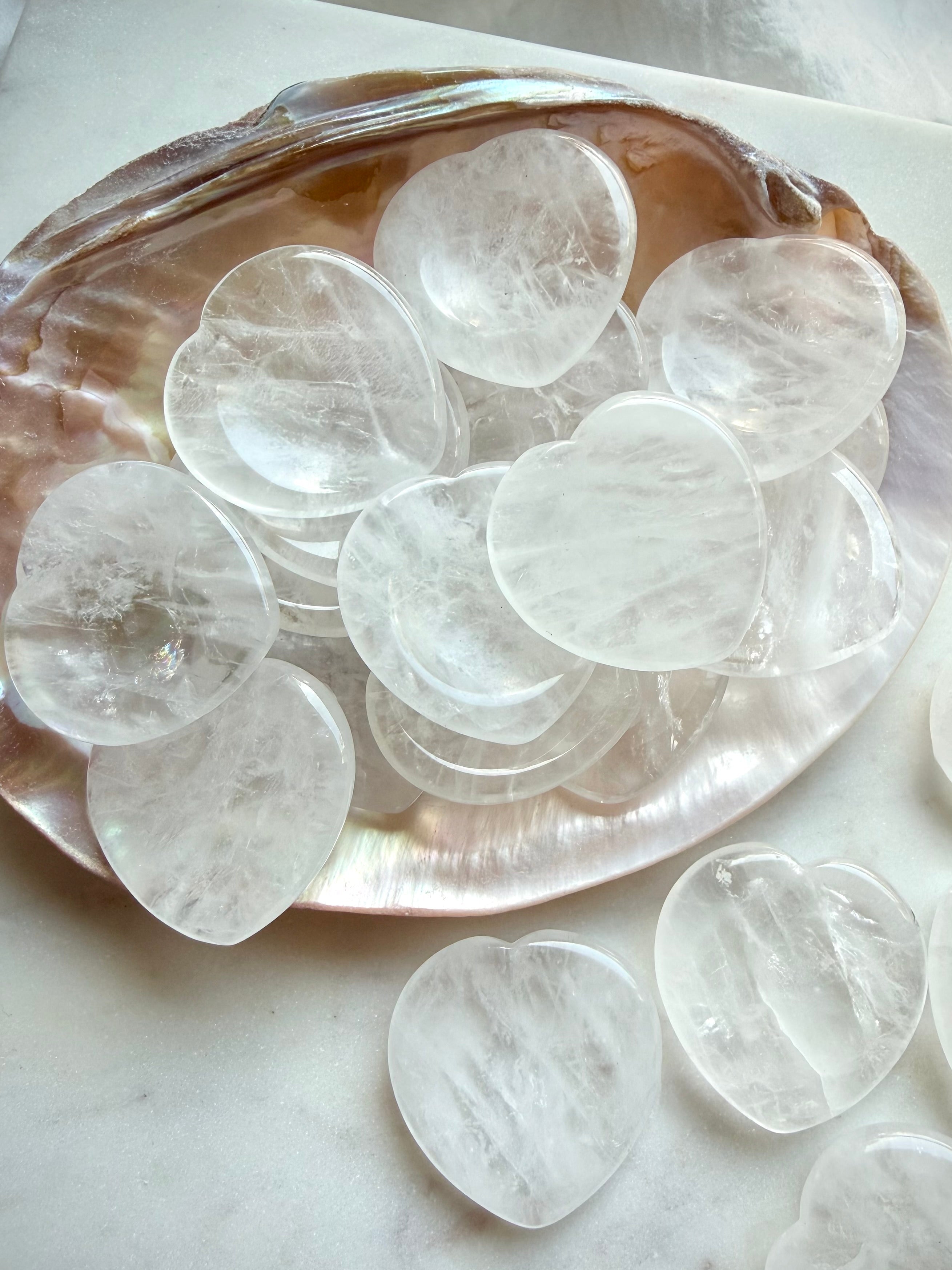 clear quartz worry stones arranged on shell dish for meditation clarity and healing energy