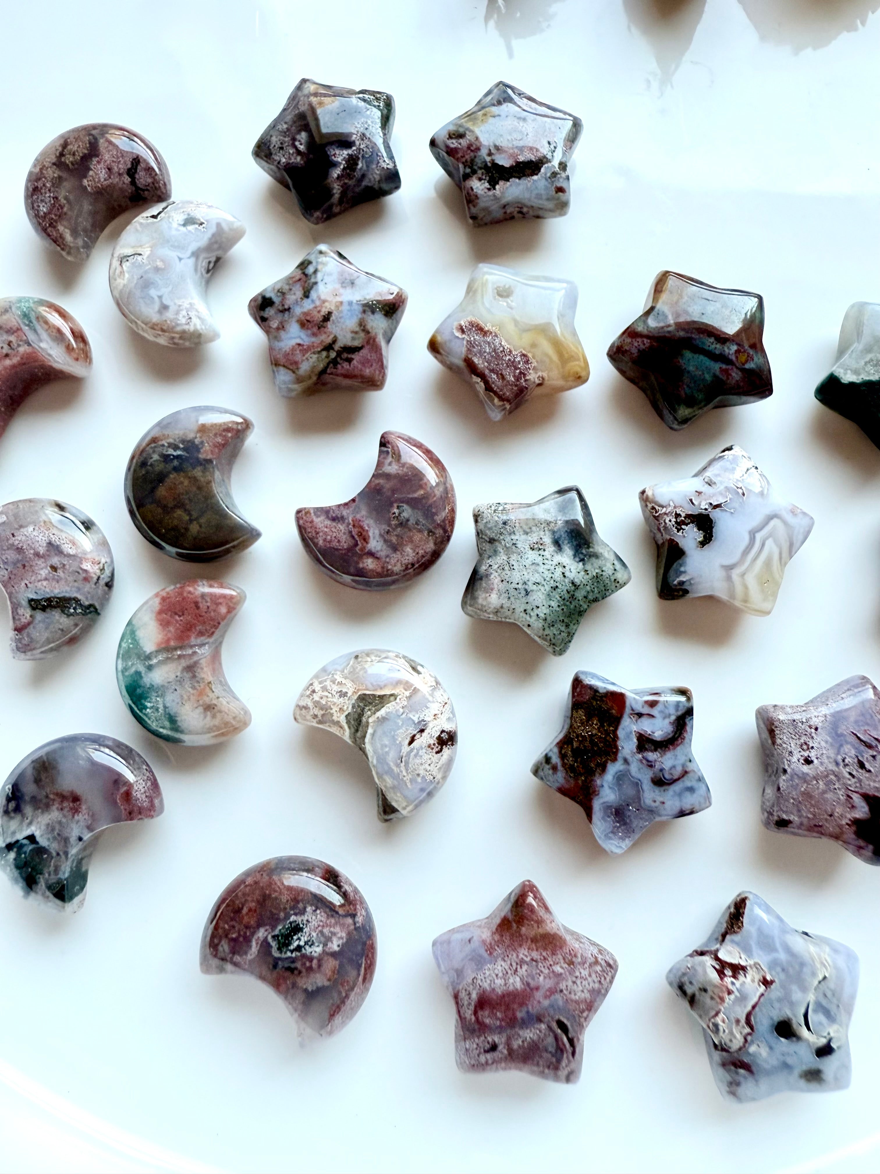Close-up of mini Ocean Jasper stars and crescent moons with unique colors, patterns, and druzy details, crystal carvings for altar décor