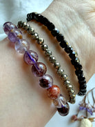 stacked crystal bracelets featuring Super Seven quartz, faceted Pyrite, and faceted Black Spinel for grounding, protection, confidence, and spiritual energy