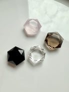 Faceted crystal hexagons in rose quartz, clear quartz, smoky quartz, and black obsidian displayed on white background