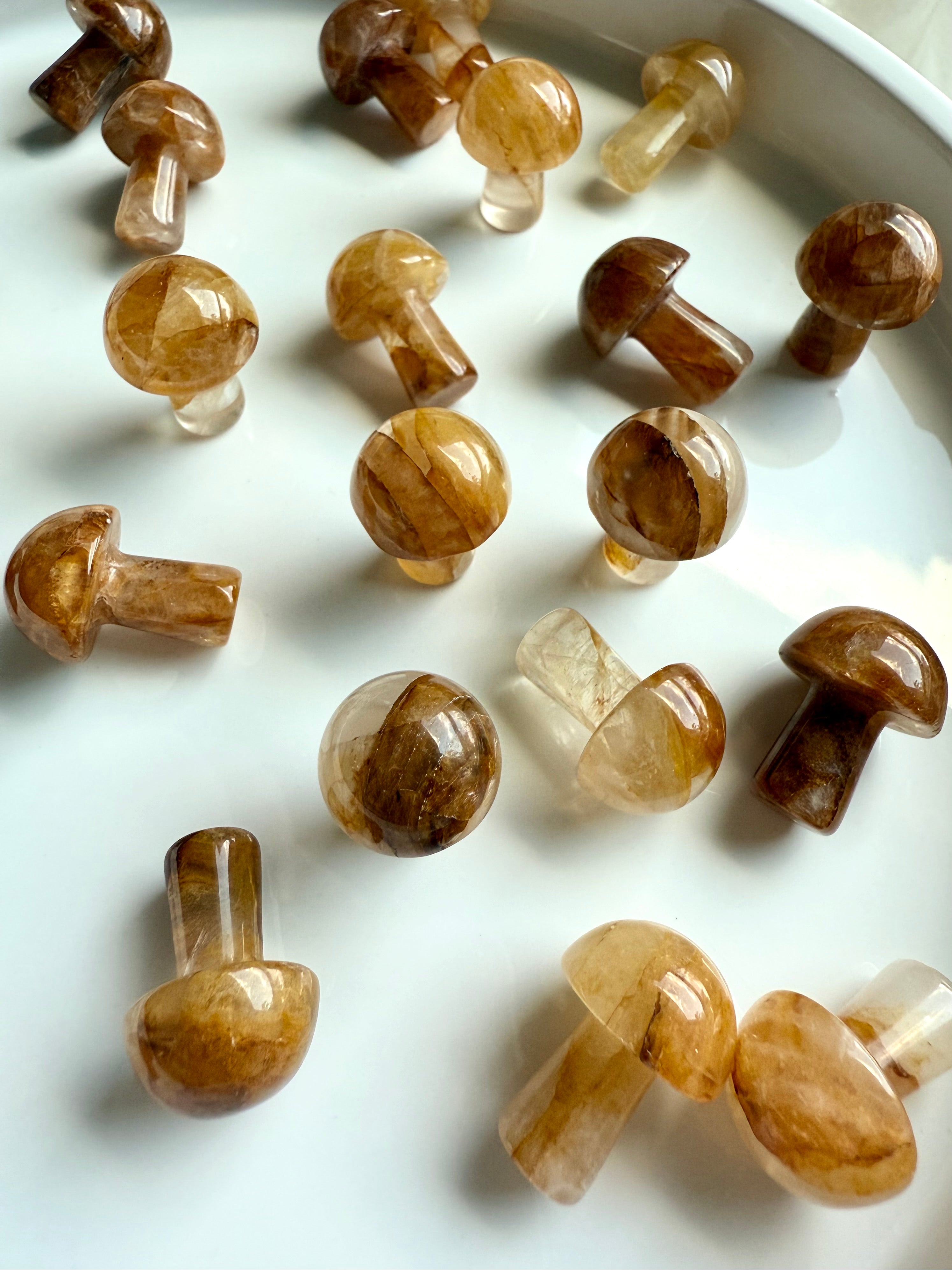 Closeup of polished Golden Healer Quartz mini mushroom carvings — warm golden tones with natural veining, perfect for chakra alignment and meditation.
