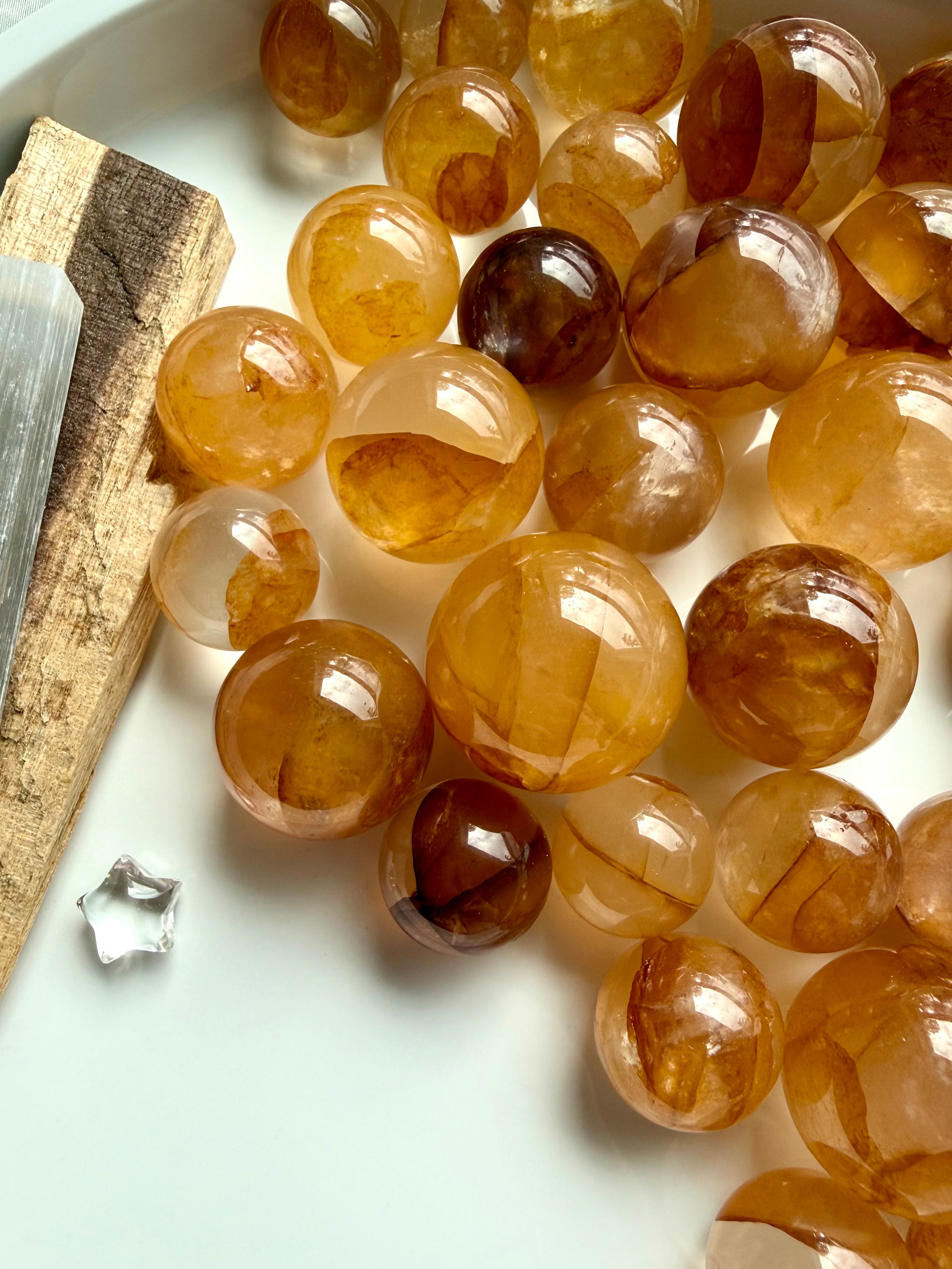 golden healer quartz mini spheres with rich honey tones and natural mineral inclusions on white tray