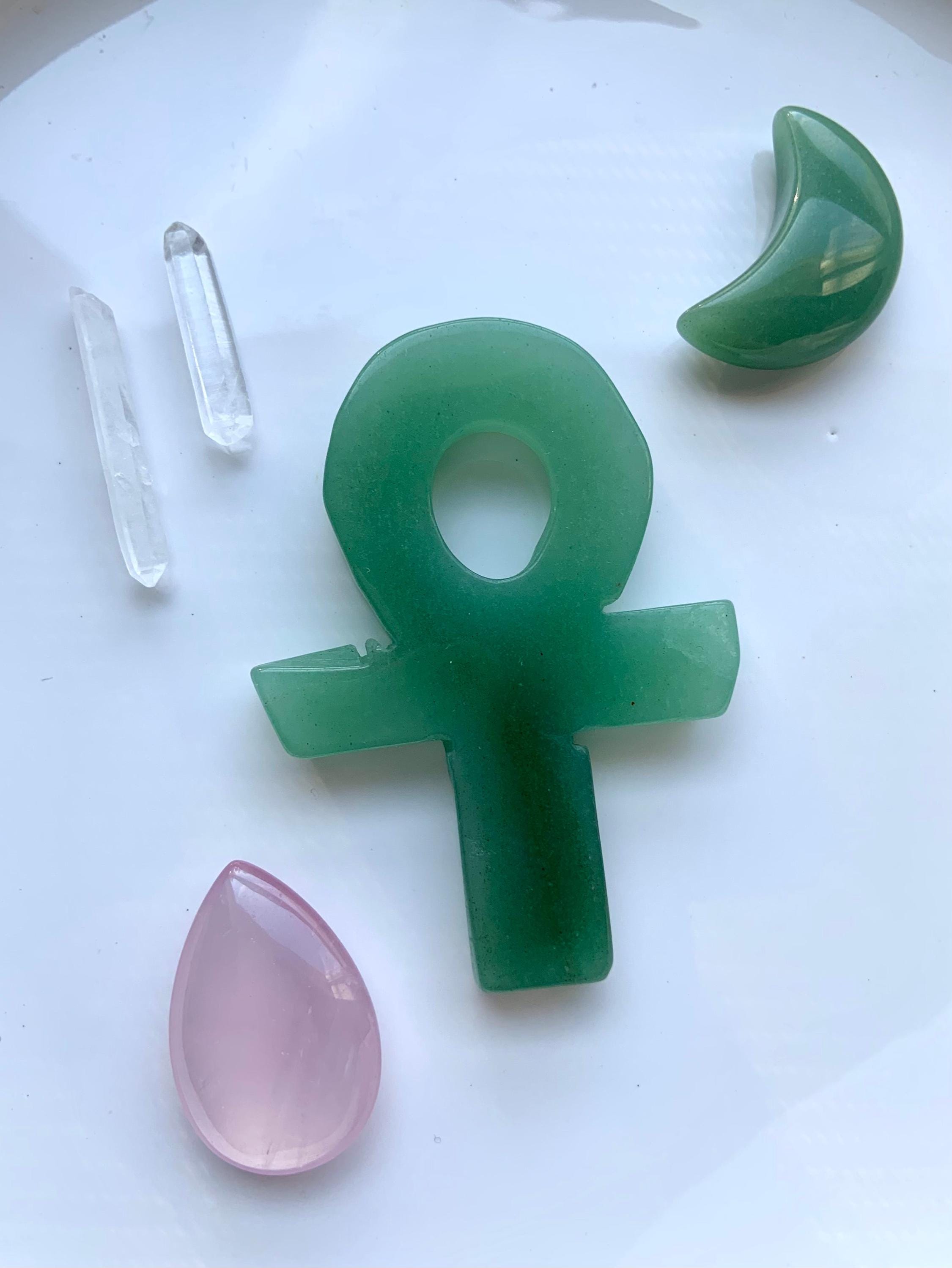 Hand Carved Green Aventurine Crystal Ankh, shown on a white plate with some other crystals