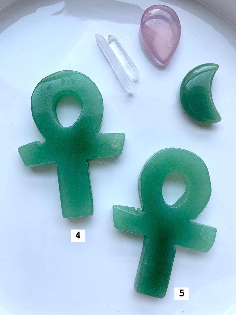 Choose your favorite Hand Carved Green Aventurine Crystal Ankh, shown on a white plate