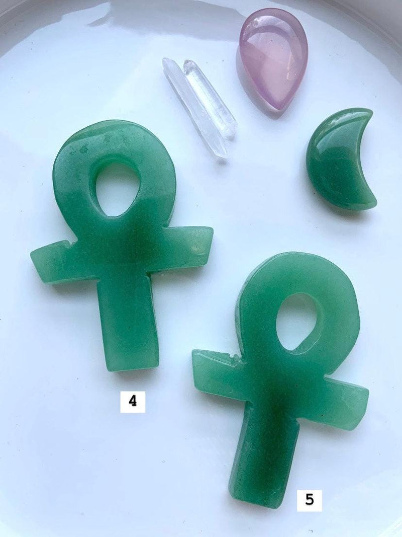 Choose your favorite Hand Carved Green Aventurine Crystal Ankh, shown on a white plate