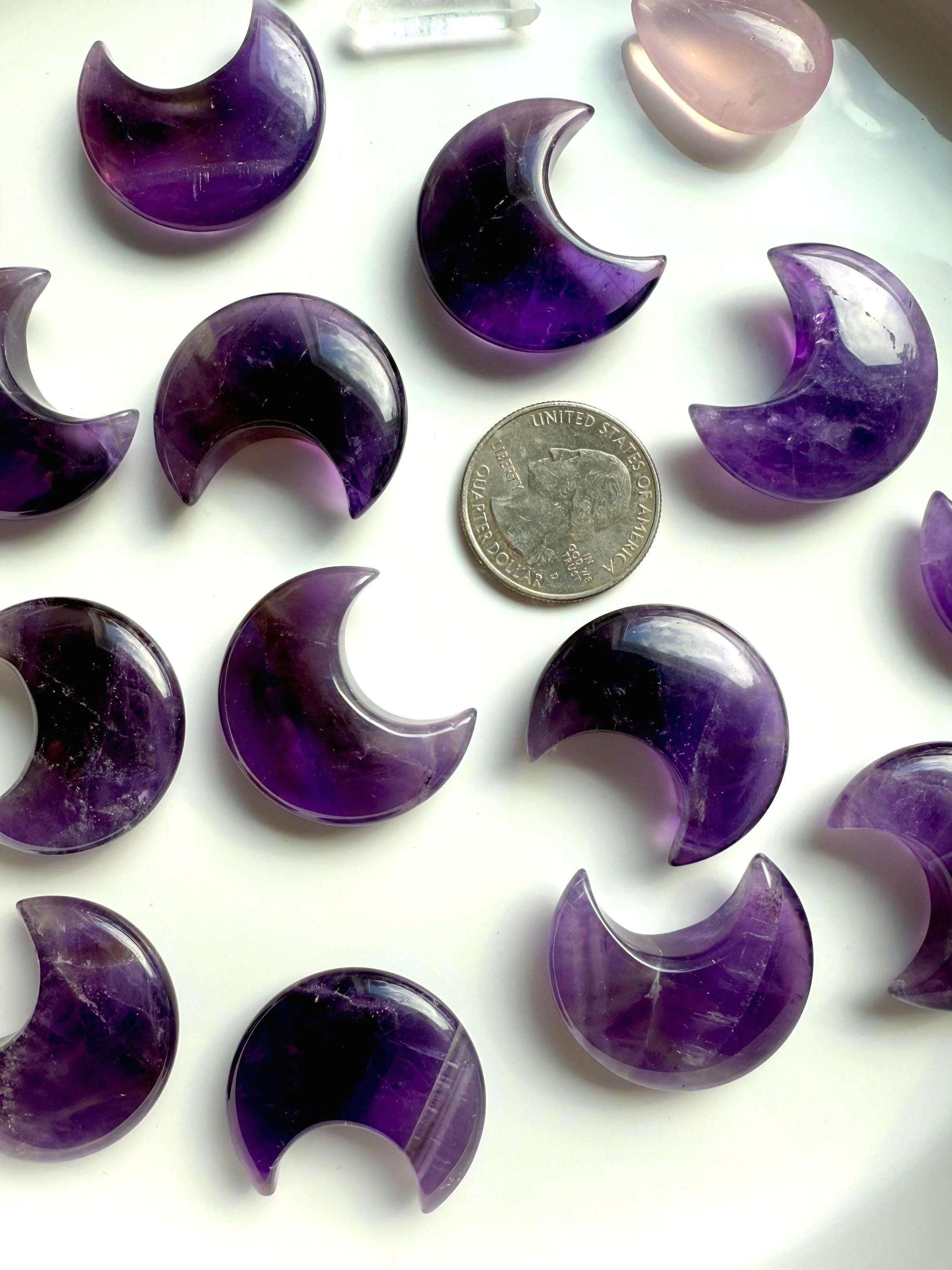High quality deep purple Dream Amethyst Moons shown on a white plate with a quarter for scale