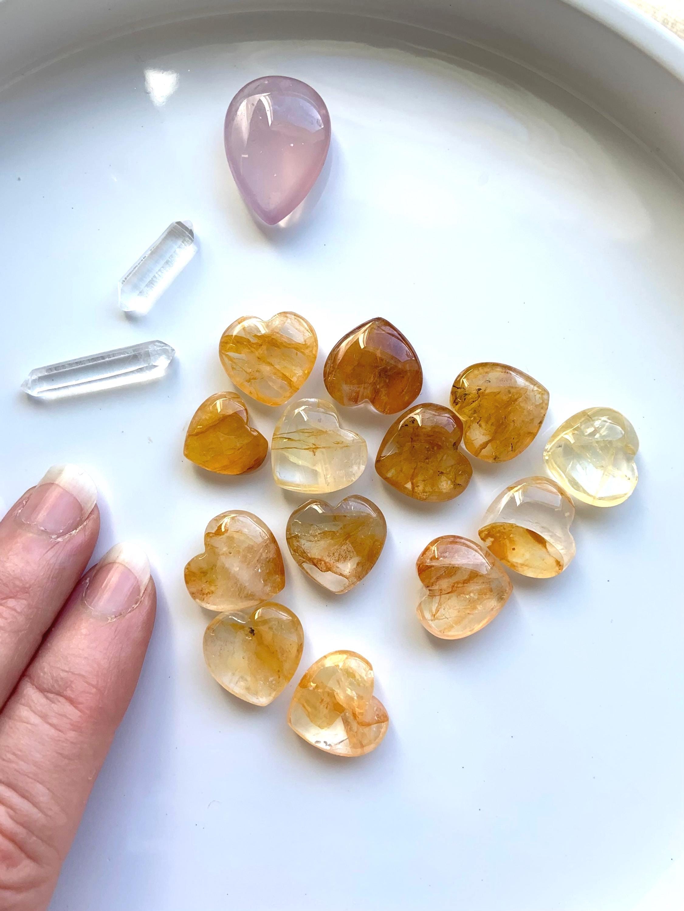 Tiny Golden Healer Crystal Hearts shown on a white plate with a few other crystals