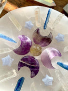 A Crystal Grid with Dream Amethyst Crescent Moon carvings and several other crystals from our shop