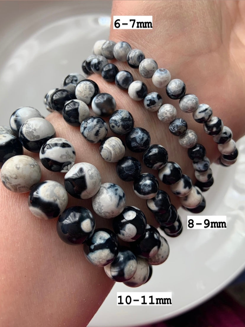 Closeup of six Orca Agate crystal bracelets labeled with bead sizes 10–11mm, 8–9mm, and 6–7mm for visual identification and variety