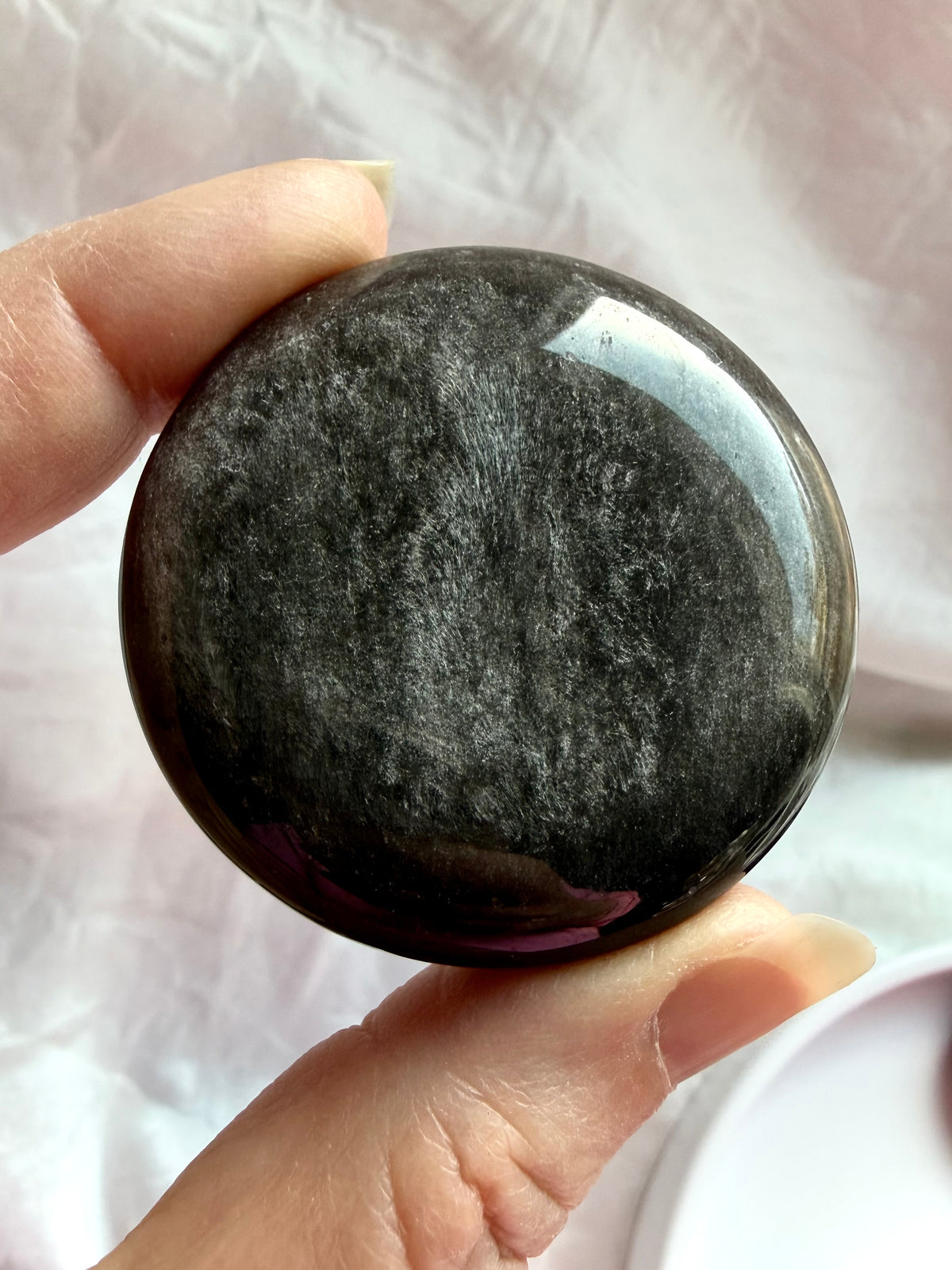 Natural Silver Sheen Obsidian palm stone with feathery silver streaks and a glossy black polished surface