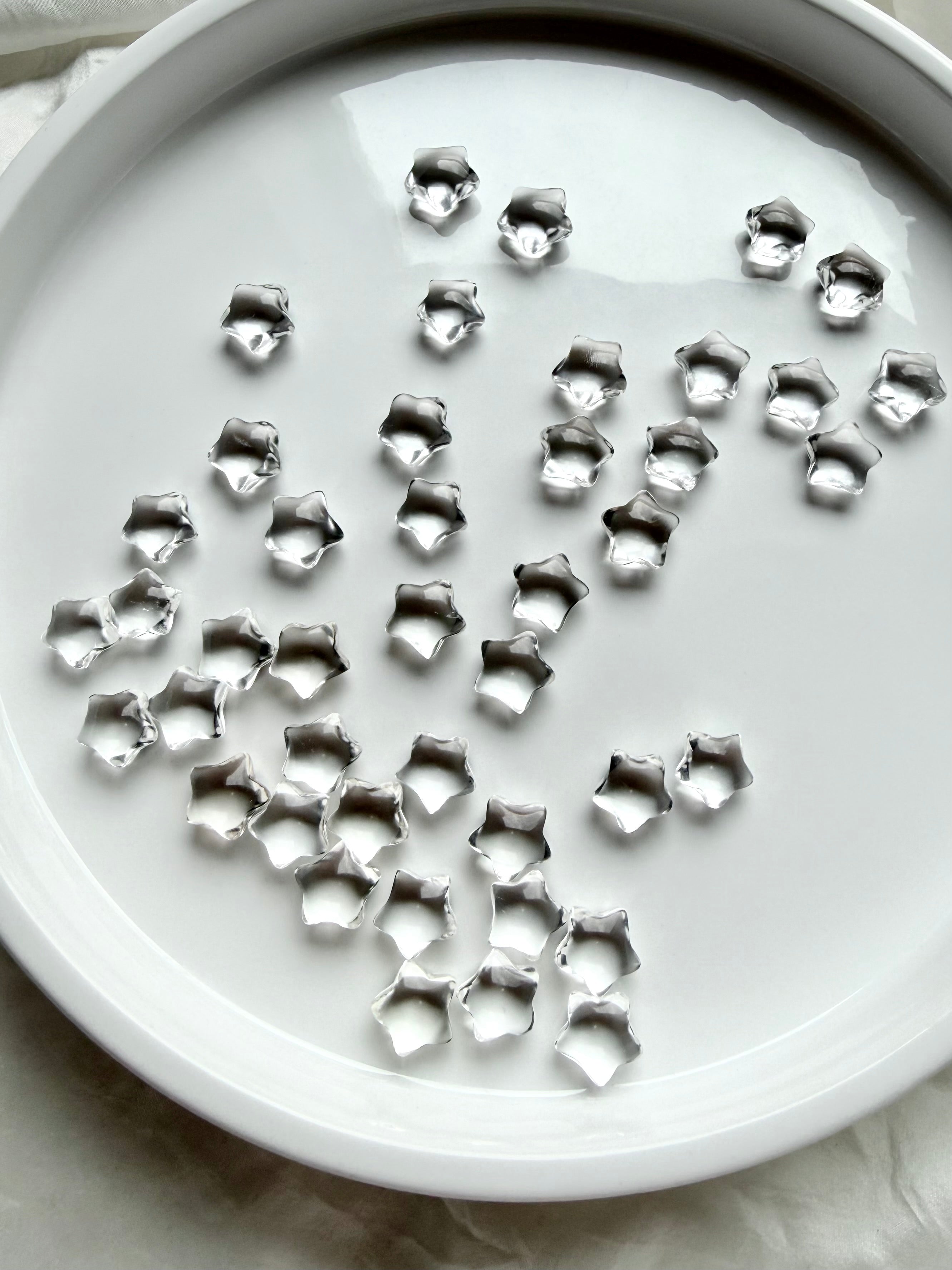 Collection of miniature Clear Quartz star crystals in a white dish, sparkling celestial gemstones for clarity, focus and intention setting