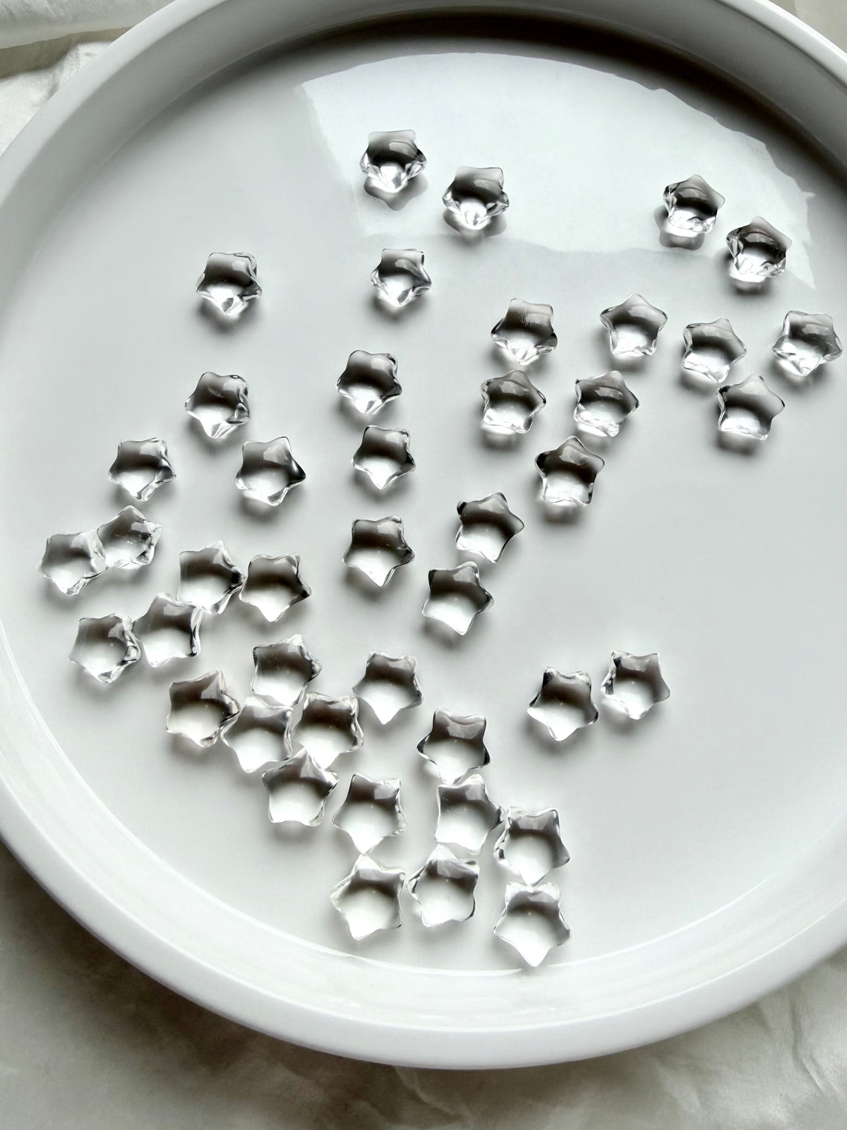 Collection of miniature Clear Quartz star crystals in a white dish, sparkling celestial gemstones for clarity, focus and intention setting